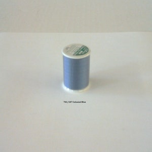 May include: A spool of blue thread with a white label that says "701/107 Colonial Blue".