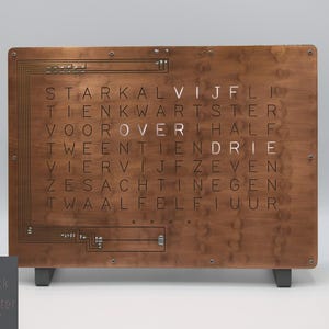 Puede incluir: Un reloj de pared de madera con acabado de cobre. El reloj muestra la hora usando palabras en holandés, como "twee" para "dos" y "half" para "media".