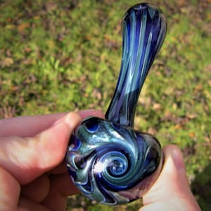 May include: A blue and green glass pipe with a swirl design. The pipe has a long, thin stem and a round bowl.