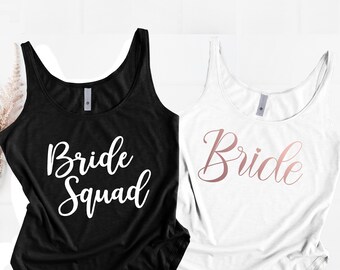 May include: Two tank tops, one black with white text that says "Bride Squad" and one white with rose gold text that says "Bride".