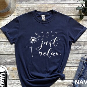 May include: Navy blue t-shirt with a white dandelion graphic and the text "just relax".