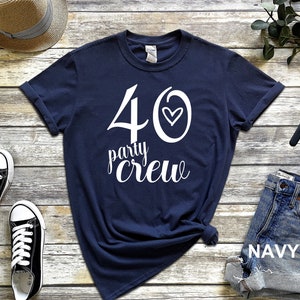 May include: A navy blue t-shirt with white text that says "40 party crew" with a small heart in the number 40.