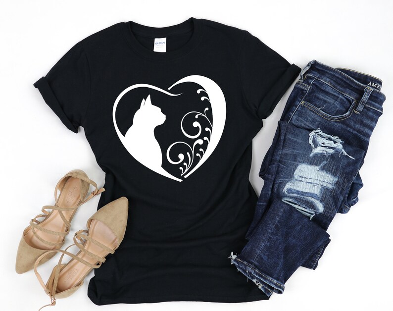 May include: Black t-shirt with a white silhouette of a cat inside a heart with floral designs.