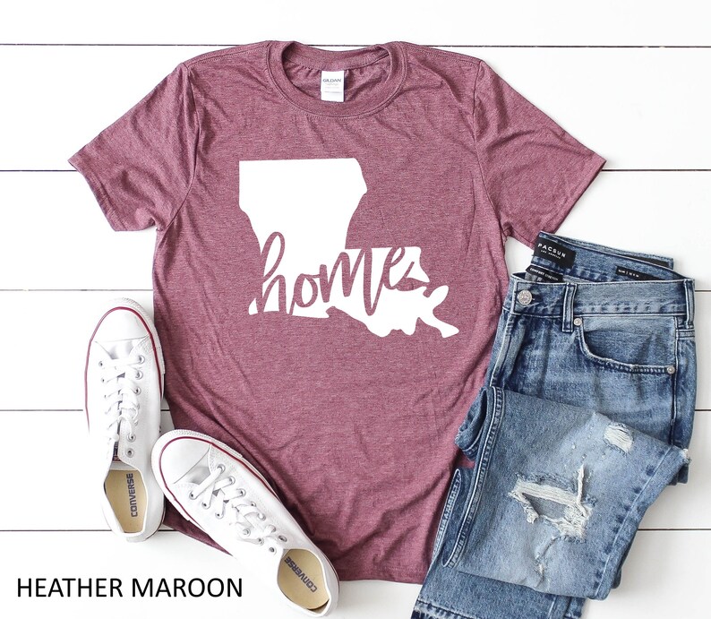 May include: Heather maroon t-shirt with a white outline of the state of Louisiana and the word "home" written in a white cursive font.
