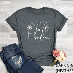 May include: Dark gray heather t-shirt with a white dandelion graphic and the text "just relax".