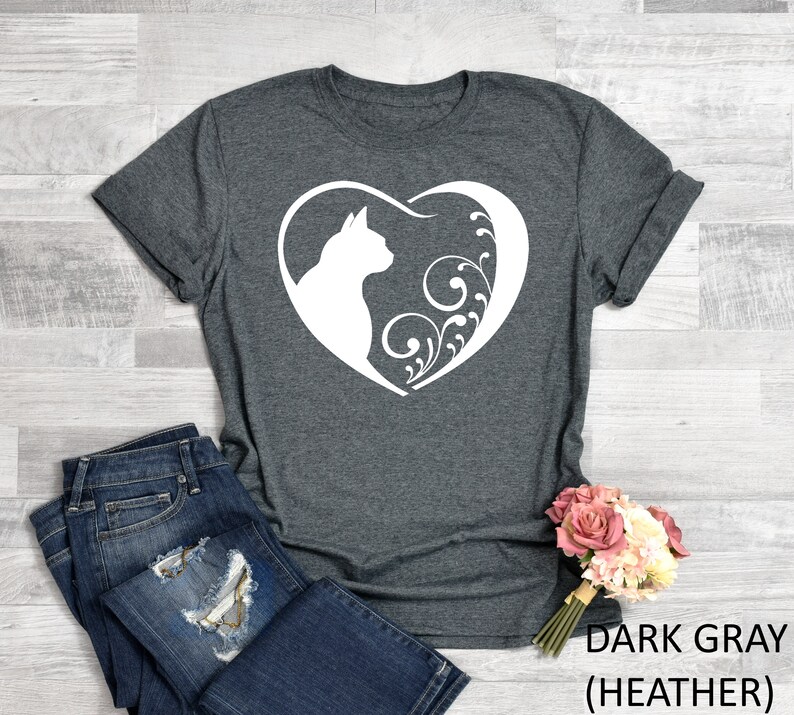 May include: Dark gray heather t-shirt with a white silhouette of a cat inside a heart with floral designs.