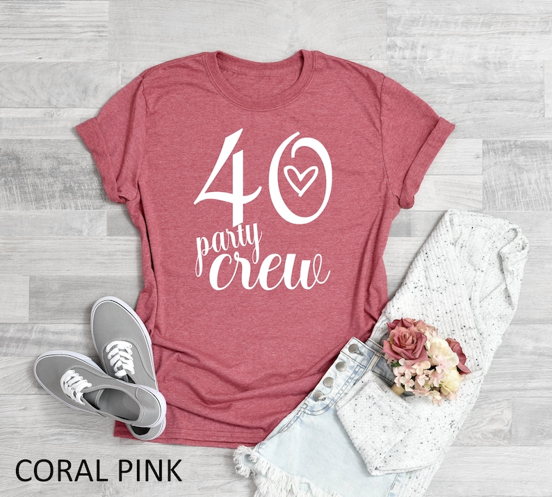 May include: Coral pink t-shirt with white text that says "40 party crew" with a small heart next to the 40.