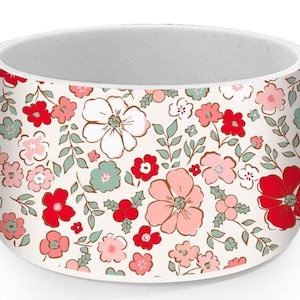 May include: White ceramic mug with a floral pattern featuring red, pink, and green flowers on a white background.