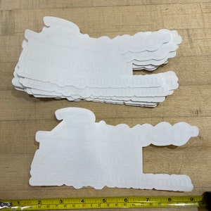 Puede incluir: Una pila de pegatinas de vinilo blanco con el texto "for-kol noun. Like a jeep but for men" impreso en ellas.