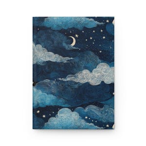 May include: A hardback journal with a celestial design. The cover depicts a dark blue night sky with swirling clouds, a crescent moon, and many stars. The clouds have white and light blue detailing, creating a dreamy, artistic aesthetic.