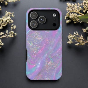 Op de afbeelding: Een telefoonhoesje met een wervelend, iriserend ontwerp in paars, roze en blauw, met glinsterende glitteraccenten. De hoes heeft een zwart cameramodule met drie lenzen.