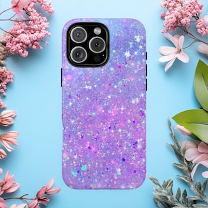 Puede incluir: Una funda de teléfono morada con purpurina y un recorte para lentes multicámara. La funda tiene un diseño brillante e iridiscente con varios colores de purpurina. La funda del teléfono está rodeada de flores rosas y hojas verdes sobre un fondo azul claro.