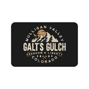Pode incluir: Tapete de rato retangular preto com um design de estilo vintage. O design inclui o texto "Mulligan Valley" e "Galt's Gulch" com um gráfico de montanha e sol. O texto "Freedom & Liberty" e "Colorado" também estão incluídos.