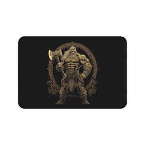 May include: Black rectangular mousepad featuring a muscular Viking warrior with a golden axe. The warrior is inside a gold-colored circular frame with intricate designs. The mousepad has a black background.