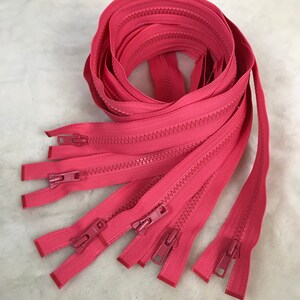 May include: A bundle of ten pink zipper closures. The zippers are all the same length and have a metal slider.