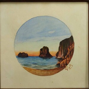 Puede incluir: Una pintura de acuarela enmarcada de un paisaje marítimo con tres islas rocosas en la distancia. La pintura está en un marco circular y tiene un cielo azul con nubes blancas. El agua es de color azul claro y la arena es de color marrón claro. La pintura está firmada "G.S.B."