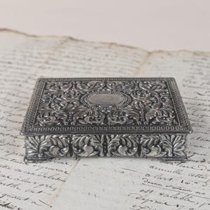 Försäljd prydnadsask i 50-talets mitt, japansk gjuten antimonkista, tung blommig skrivbordsaccessoar, ca 1950