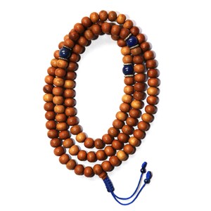 May include: A brown wooden mala bead necklace with blue gemstone accents. The necklace is strung with a blue cord and has a tassel at the end.