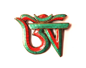 May include: A green and red Om symbol made of inlaid stone. The symbol is a popular Buddhist and Hindu symbol of peace and harmony.