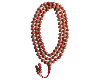 May include: A red sandalwood mala with 108 beads and a tassel. The mala is used for meditation and prayer in Hinduism and Buddhism.