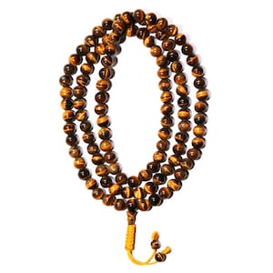 May include: A brown and gold tiger's eye beaded mala necklace with a yellow tassel.
