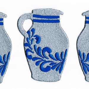 Puede incluir: Tres jarras de cer&aacute;mica azul y blanca con un dise&ntilde;o floral. Las jarras tienen un asa y una boca ancha.