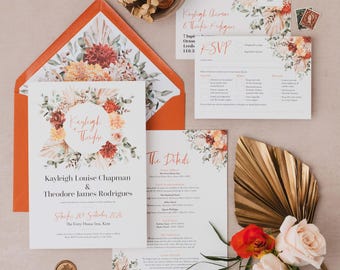 May include: A wedding invitation suite featuring floral designs in shades of orange, red, and cream. The suite includes an invitation, RSVP card, details card, and envelope. The invitation reads "Kayleigh & Theodore" and "Kayleigh Louise Chapman & Theodore James Rodrigues".