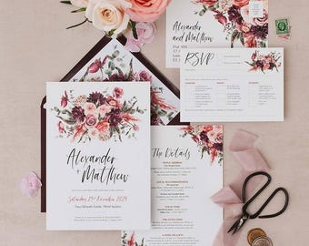 May include: Wedding invitation suite featuring floral designs in burgundy, pink, and cream. The suite includes an invitation, RSVP card, and details card, with the names "Alexander + Matthew" prominently displayed. A pair of scissors and flowers are also present.