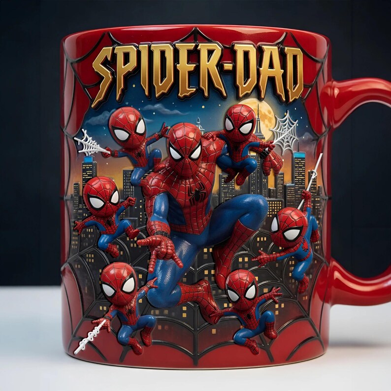 Puede incluir: Taza de cer&aacute;mica roja con Spider-Man y varias figuras m&aacute;s peque&ntilde;as de Spider-Man. La taza tiene las palabras "SPIDER-DAD" en letras doradas. El fondo representa un paisaje urbano con una luna llena y telara&ntilde;as.