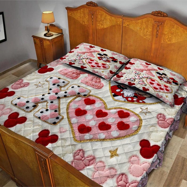 Puede incluir: Un edred&oacute;n acolchado y dos fundas de almohada con un tema de Minnie Mouse. El edred&oacute;n tiene un fondo blanco con detalles en rosa, rojo y dorado, incluyendo corazones, estrellas e im&aacute;genes de Minnie Mouse. Las fundas de almohada tienen un dise&ntilde;o similar.