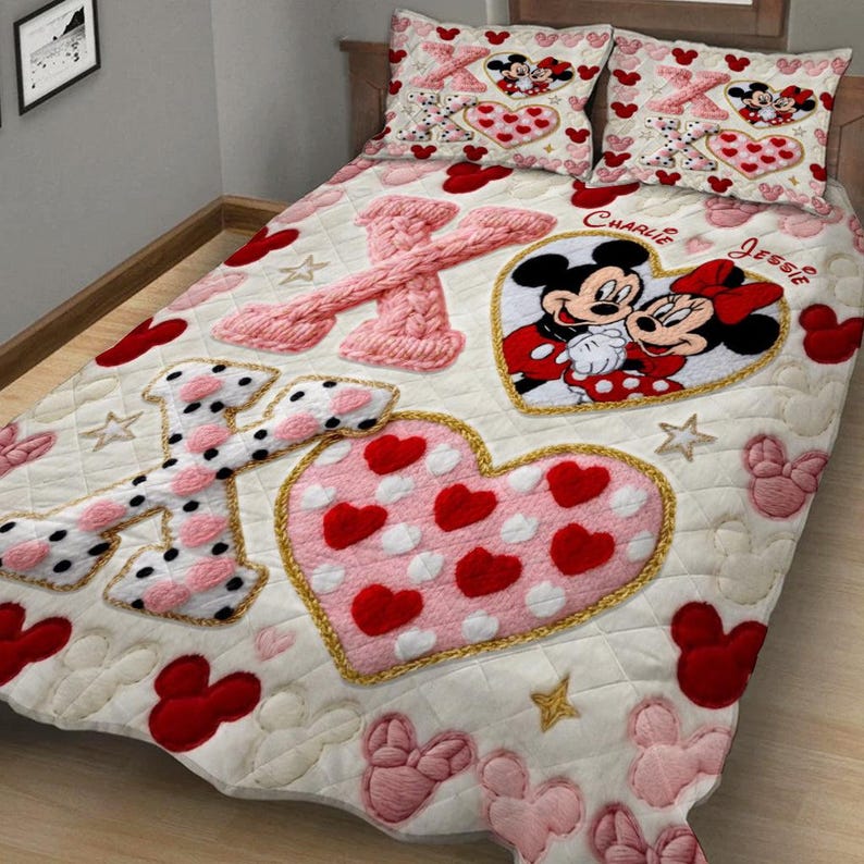 Puede incluir: Un edred&oacute;n crema y dos fundas de almohada con un tema de Mickey y Minnie Mouse. El edred&oacute;n tiene un gran coraz&oacute;n rosa con corazones rojos, las letras "X" y "O", y un gr&aacute;fico de Mickey y Minnie Mouse. Las fundas de almohada tienen dise&ntilde;os similares.