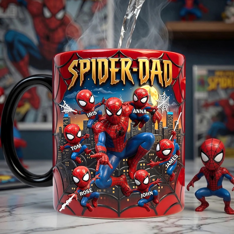 Puede incluir: Taza de cer&aacute;mica roja con las palabras "SPIDER-DAD" en letras doradas. La taza presenta un dise&ntilde;o de Spider-Man con varias figuras m&aacute;s peque&ntilde;as de Spider-Man y nombres personalizados. Tambi&eacute;n hay una peque&ntilde;a figura de Spider-Man.