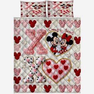 Puede incluir: Un juego de cama acolchado blanco con Mickey y Minnie Mouse. El juego incluye un edred&oacute;n y dos fundas de almohada. El edred&oacute;n tiene un gran coraz&oacute;n con Mickey y Minnie, y los nombres "Charlie" y "Jessie". El edred&oacute;n est&aacute; decorado con corazones y formas de Mickey Mouse.