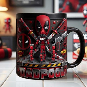 Puede incluir: Taza de cer&aacute;mica negra con un dise&ntilde;o de Deadpool rojo y negro. La taza tiene un asa y un gr&aacute;fico detallado de Deadpool con su familia, espadas y una pistola. El texto "DADPOOL" se muestra de forma destacada.