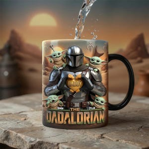 Puede incluir: Taza de cer&aacute;mica con un dise&ntilde;o de The Mandalorian sosteniendo un objeto en forma de coraz&oacute;n con la palabra "DADDY". La taza tambi&eacute;n presenta a Grogu y el texto "THE DADALORIAN" y los nombres "Cindy", "Abby", "Simon" y "Dylan". La taza tiene un asa negra.