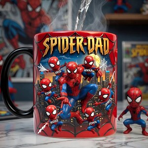Puede incluir: Taza de cer&aacute;mica roja con las palabras "SPIDER-DAD" en letras doradas. La taza presenta un dise&ntilde;o de Spider-Man con varias figuras m&aacute;s peque&ntilde;as de Spider-Man y nombres personalizados. Tambi&eacute;n hay una peque&ntilde;a figura de Spider-Man.