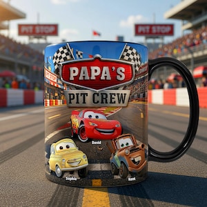 Puede incluir: Una taza de cer&aacute;mica con asa negra, decorada con tem&aacute;tica de carreras. La taza muestra el texto "PAPA'S PIT CREW" sobre im&aacute;genes de coches de carreras animados. Los nombres "David", "Sophia" y "Kent" est&aacute;n debajo de los coches. Banderas a cuadros y un fondo de circuito completan el dise&ntilde;o.