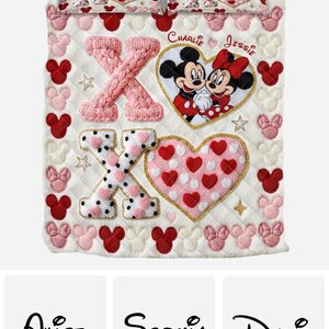 Puede incluir: Una colcha acolchada blanca con un dise&ntilde;o de Mickey y Minnie Mouse rosa y rojo. Incluye las letras X y O, corazones y siluetas de Mickey Mouse. Los nombres "Charlie" y "Jessie" est&aacute;n bordados en la parte superior.