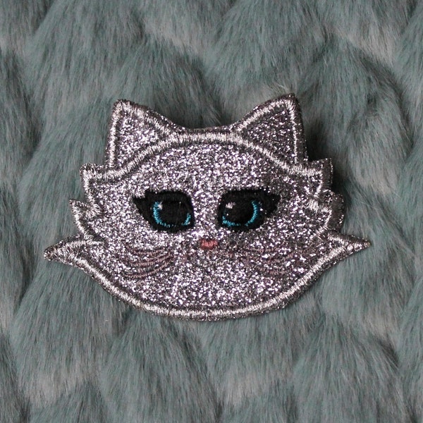 Broche MRAOW badge tête de chat tissu gris paillettes argentées brodé visage yeux bleus nez rose museau moustaches grises made in France