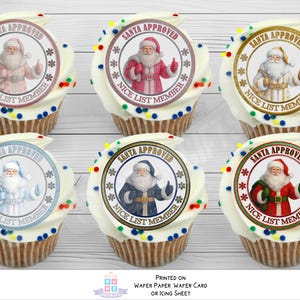 May include: Six cupcakes topped with circular edible toppers featuring Santa Claus in various coloured outfits. Each topper includes the text SANTA APPROVED and NICE LIST MEMBER with snowflake accents. The cupcakes have white frosting with colourful sprinkles.