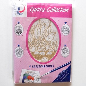 Könnte beinhalten: Eine rosa und weiße Verpackung mit dem Text "Gutta-Collection" und "4 PASSEPARTOUTS". Die Verpackung enthält vier weiße Papierbögen mit goldenen Umrissen von Tulpen und einem Vogel. Die Verpackung enthält auch einen Pinsel.