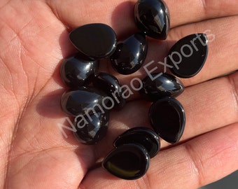May include: A collection of black gemstone drops, likely onyx, in various sizes and shapes. The stones are smooth and polished, with a glossy finish.