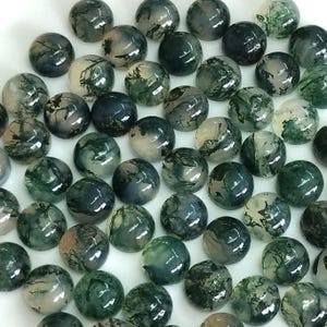 May include: A collection of polished, round gemstones with a moss agate appearance. The stones feature a mix of translucent, milky white, and deep green colors, with intricate, natural patterns resembling landscapes.