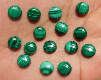May include: A collection of 15 round, green malachite cabochons. The cabochons are smooth and polished, with a variety of patterns and swirls.