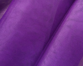 May include: Close-up of a vibrant purple fabric with a fine, net-like texture. The material is folded, creating shadows and highlighting the sheen of the textile. The color is a rich, saturated shade of purple.