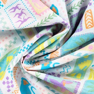 Könnte beinhalten: Weißer Stoff mit einem farbenfrohen tropischen Muster. Das Design umfasst verschiedene Formen und Illustrationen in Blau-, Gelb-, Orange-, Lila- und Grüntönen. Der Stoff ist gefaltet und zeigt die sich wiederholenden Elemente des Musters.