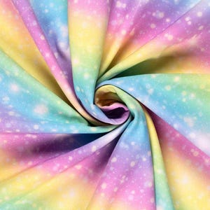 Könnte beinhalten: Ein gewirktes Gewebe in Regenbogenfarben, darunter Gelb, Rosa, Blau und Grün. Der Stoff hat einen weichen, schimmernden Effekt mit weißen Sprenkeln, wodurch ein verträumtes, himmlisches Aussehen entsteht. Der Stoff ist spiralförmig zusammengefasst.