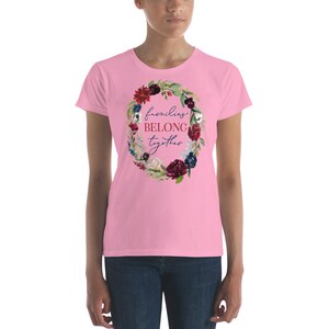 May include: Pink women's t-shirt with a floral wreath design and the text "families belong together" in blue and red lettering.