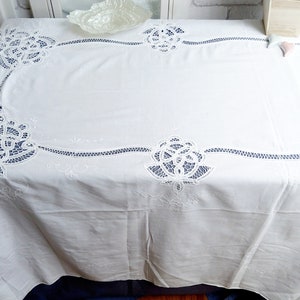 Puede incluir: Mantel blanco con delicados dise&ntilde;os florales bordados. El mantel tiene un patr&oacute;n de encaje con detalles intrincados.