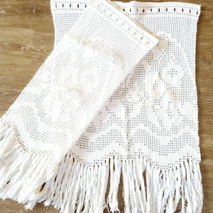 Peut inclure: Deux panneaux en crochet blanc avec des franges. Les panneaux présentent un motif floral délicat et sont réalisés avec un fil fin.